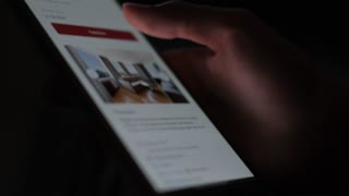 A man selects real estate in an online service on a smartphone, close-up