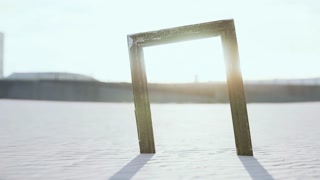 Empty wooden picture frame on the beach sand