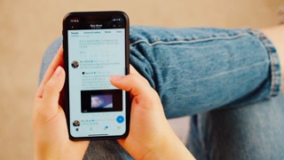 BARCELONA, SPAIN, 11 APRIL, 2022: Woman reading Elon Musk Twitter, starlink, tesla and spacex news on phone, POV. Student holding smartphone. Reading web page close-up.