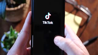 NEW YORK CITY - CIRCA 2021: Finder scrolling Tik Tok video sharing social networking service